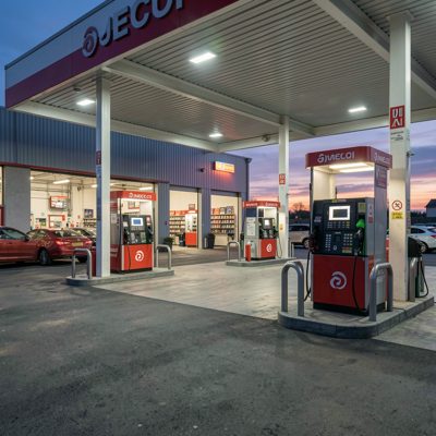 a garage forecourt with fuel pumps at dusk