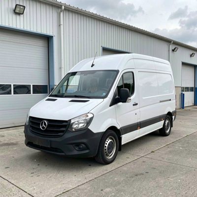 a white panel van outside a warehouse, no license plate