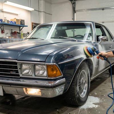 a saloon car being detailed with a polisher, no license plate