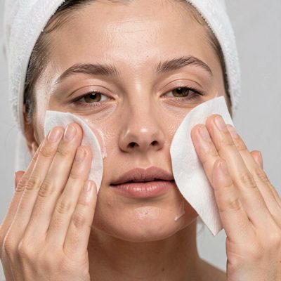 a face being cleansed with a cotton pad