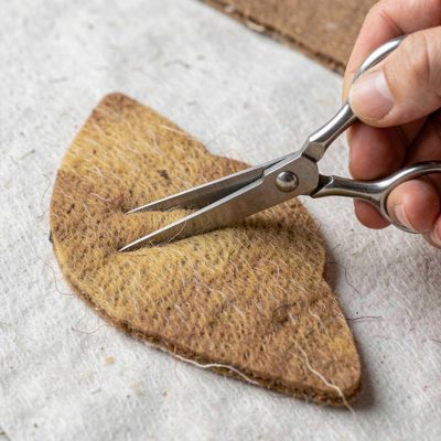 a felt shape being cut with small scissors