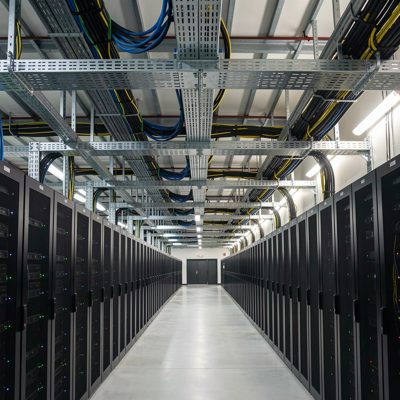 a data centre with overhead cable trays crossing the ceiling