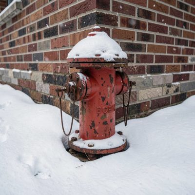 a fire hydrant on a snowy corner