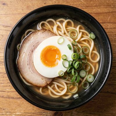 a bowl of ramen with soft egg and spring onion from above