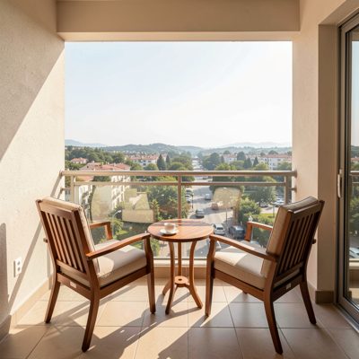a hotel balcony with two chairs and a view
