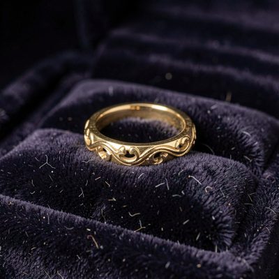 a gold ring on a dark velvet cushion