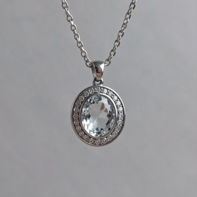 a pendant hanging in front of a plain backdrop