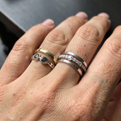 a hand wearing three stacked rings