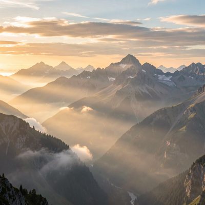 a misty mountain range at sunrise with layered peaks