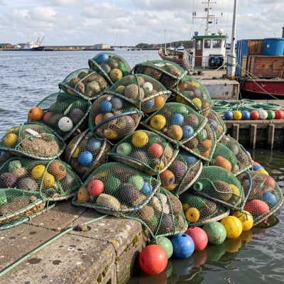 nets piled on a quayside with floats
