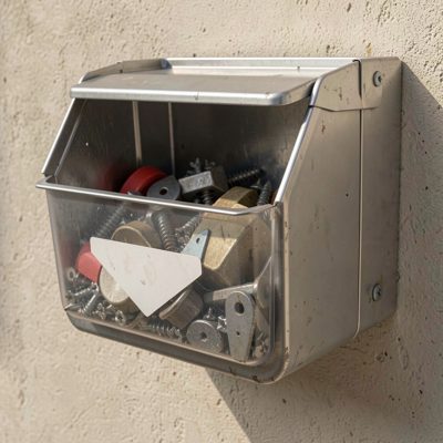a sharps bin mounted on a wall