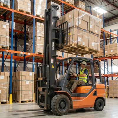 a forklift lifting a pallet into a rack