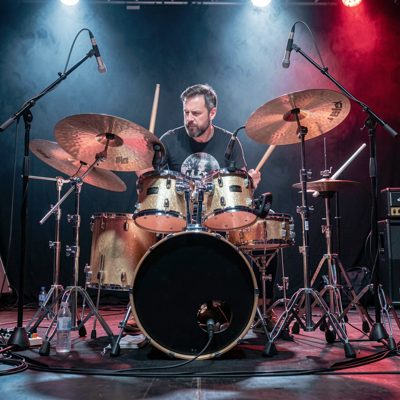 a drummer mid performance behind a full kit