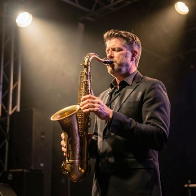 a saxophone player lit by a single stage light