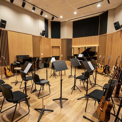 a rehearsal room with instruments and music stands