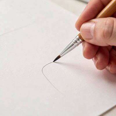 a nail art brush painting a fine line
