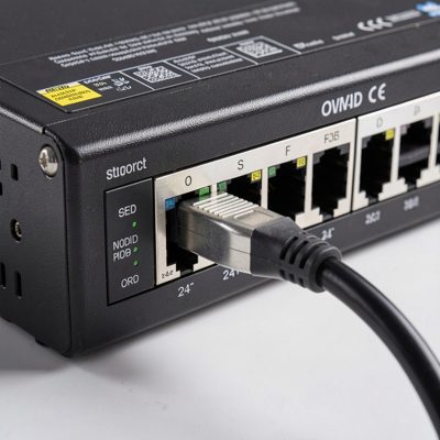 a cable being plugged into port one of a 24 port switch