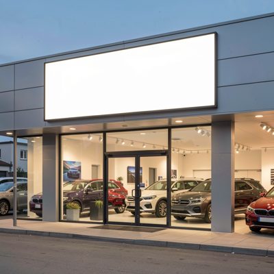 a car showroom frontage with a blank illuminated sign, blank empty sign board, no text, no lettering, no logo