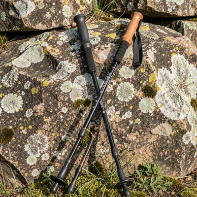 a pair of trekking poles against a rock
