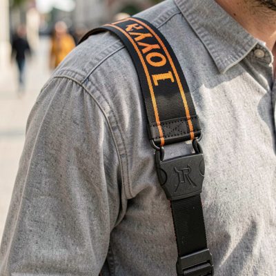 a camera strap over a shoulder