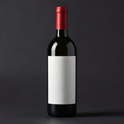 a wine bottle with a blank unprinted white label on a dark background