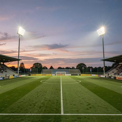 a football pitch with floodlights at dusk