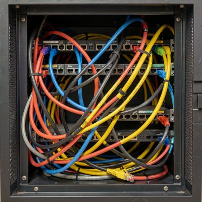 a tangle of ethernet cables behind a rack cabinet