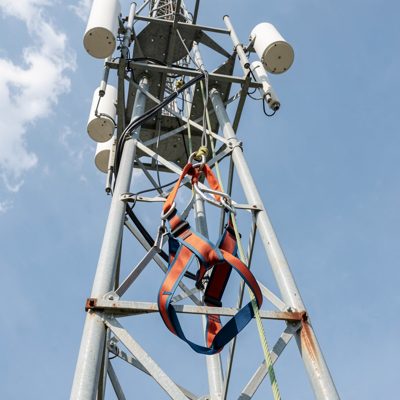 a climbing harness clipped to a communications tower